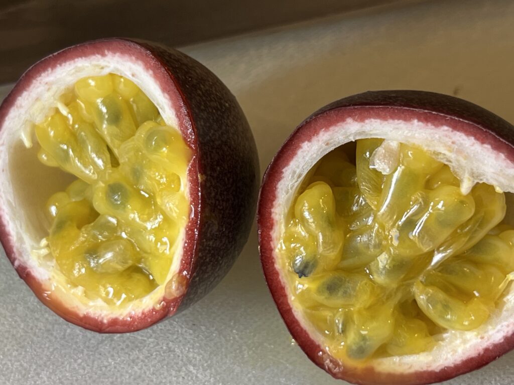 Cut open purple passion fruit on a white cutting board Those Someday Goals