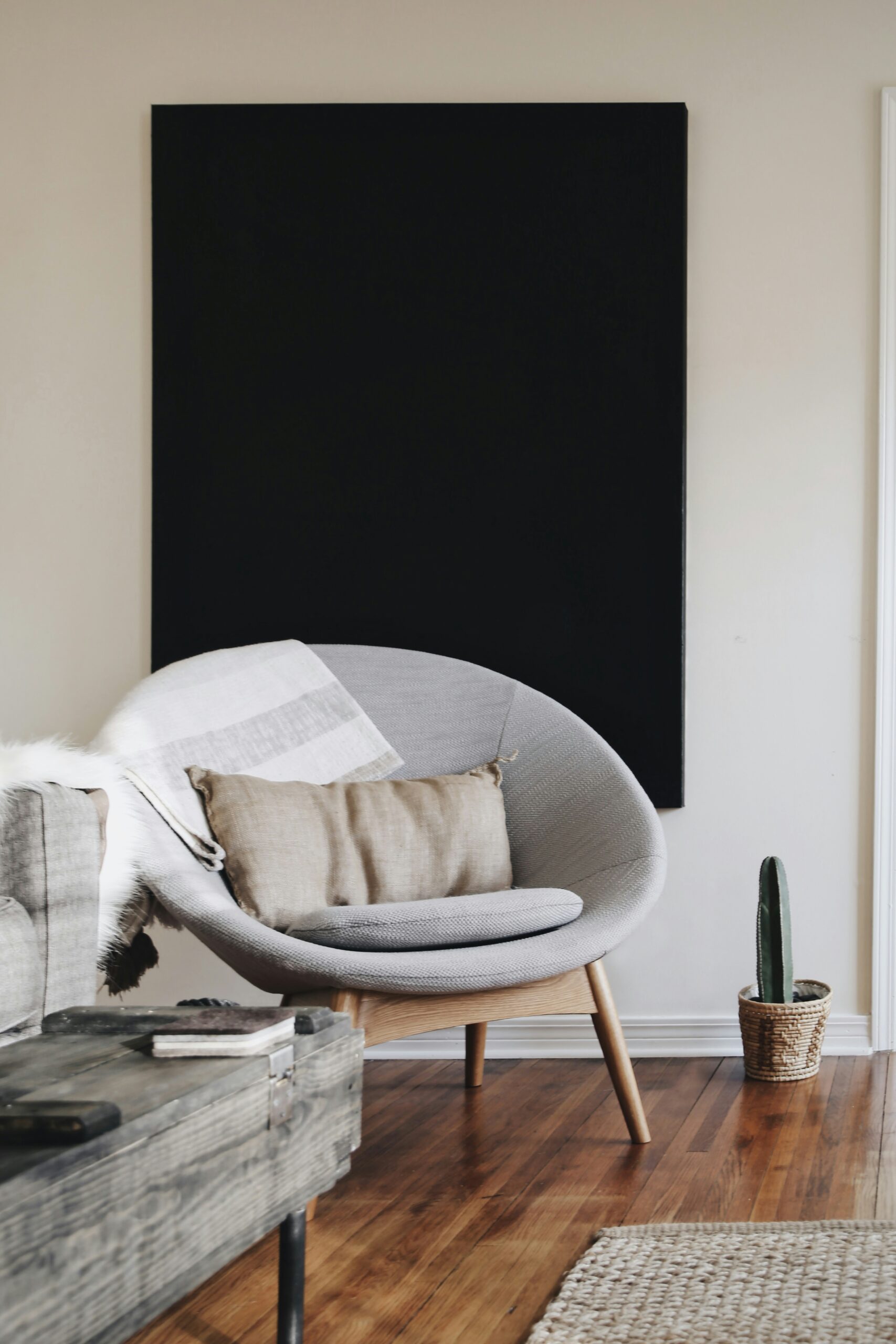 Spindle legs on an oval chair, large-scale black art, wooden media table, jute rug, avery-klein-JaXs8Tk5Iww-unsplash decorating tips for small spaces 30-day decluttering challenge minimalism game