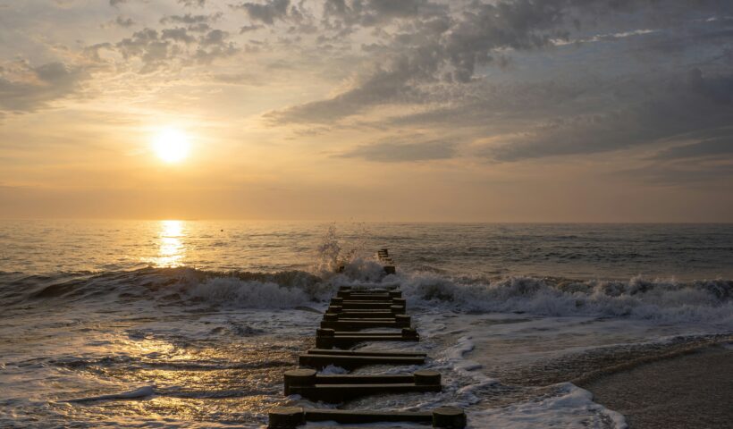 Finding your Resilience Sunrise over beach and water covered jetty bryce-wendler-3Uq1j0VGvqs-unsplash