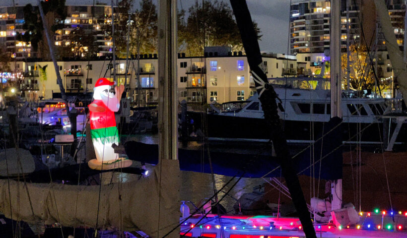 Boats prepping with inflated santa marina boat parade holiday lights Christmas decorations