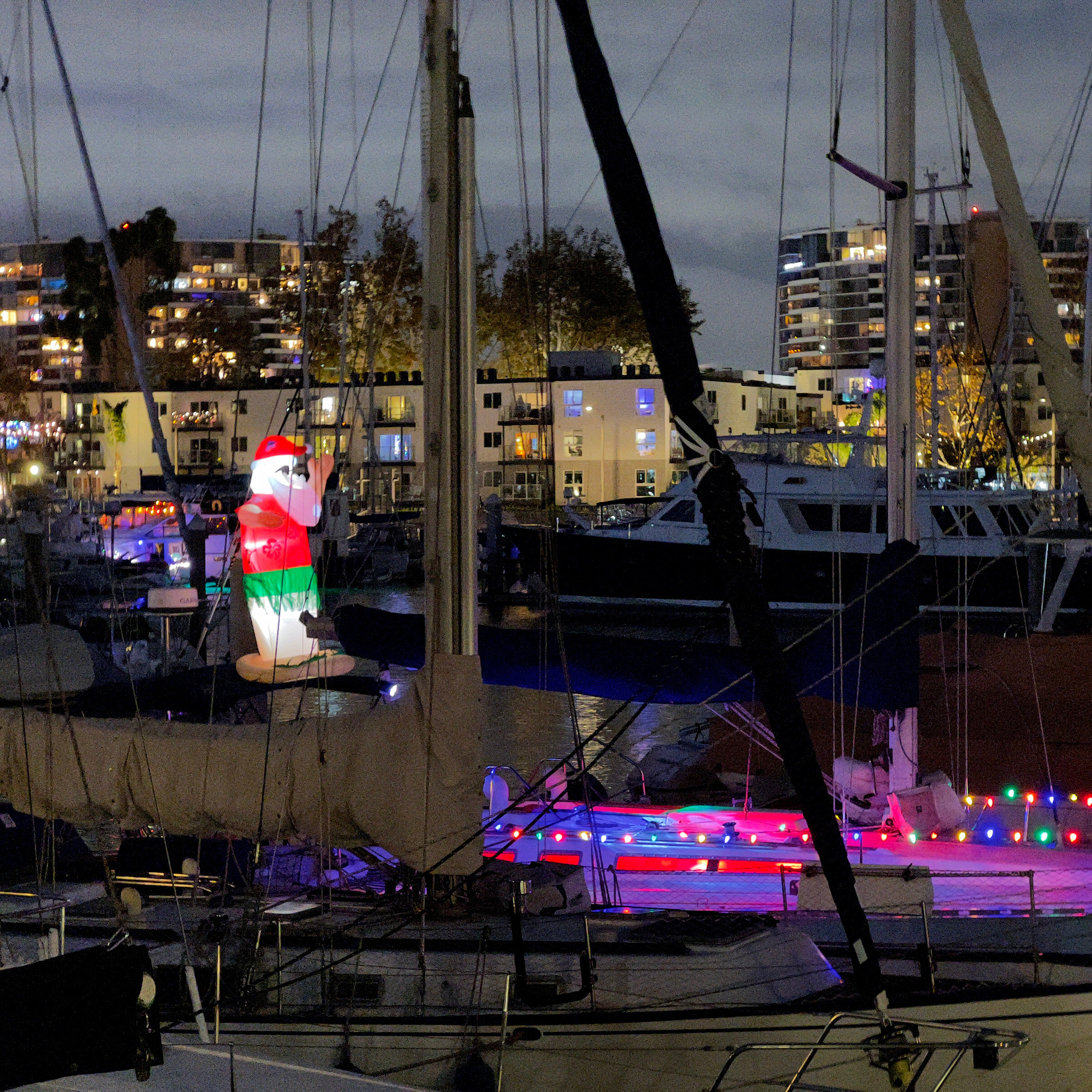 Boats prepping with inflated santa marina boat parade holiday lights Christmas decorations