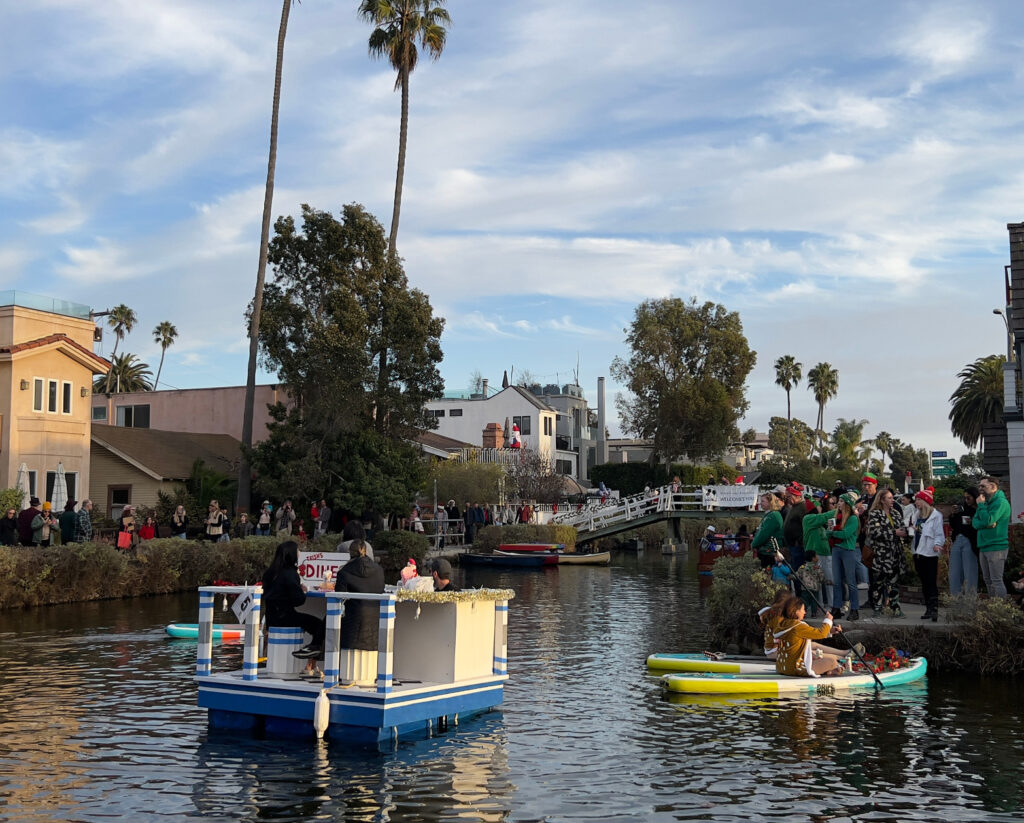 Diner boat and reindeer paddle boards Venice Canal Boat Parade Christmas Decorations Holiday Decorations California Celebration